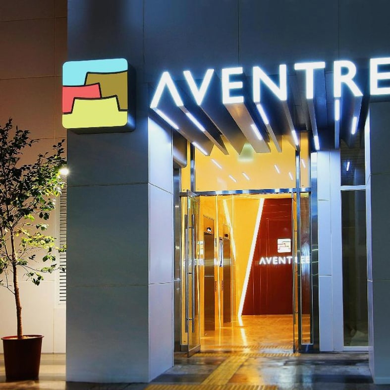 조명이 켜진 AVENTREE 간판과 건물 출입구의 모습입니다.