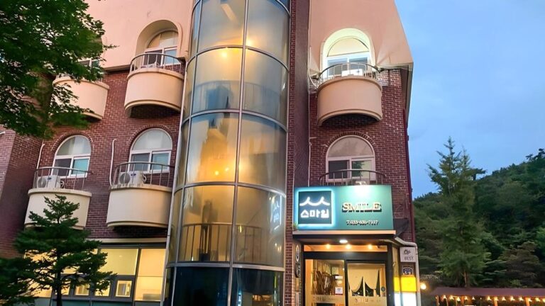 원통형 유리 구조물과 간판이 있는 건물의 외관입니다.